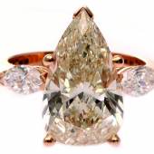 Kat.-Nr. 1079 Bedeutender Diamant-Ring 750/-Roségold, 21.Jh. Hochdekorativer Ring mittig m. 1 leicht champagnerfarbenen Diamant-Tropfen, ca. 5,08 ct. vs2, in 1 klassischen 4- Krappenfassung. Flankiert von 2 navette- förmigen Diamanten, zus. ca. 0,63 ct. tw si2+p2, ca. 5,9 g, RW 52. Schätzpreis 34.000,- EUR