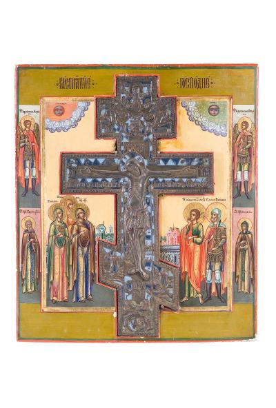 Kalenderikone (5089/10): Kreuzigung Christi, Russland, wohl Palech, Ende 19. Jh. Starkes Nadelholz-Einzelbrett mit zwei gegenständigen Rückseiten-Sponki. Tempera auf Kreidegrund über Leinwand. Kovtscheg. Konturritzung. Nimben und Gewänder partiell blattvergoldet. Mittig eingelassenes, in Blautönen emailliertes Bronzekruzifix mit dem gekreuzigten Christus. Auf der linken Seite flankiert von den drei Marien, auf der rechten Seite von dem Lieblingsjünger Johannes und dem Hauptmann Longinus vor Architekturkulisse. Am oberen Bildrand von Wolkenbändern gerahmt Sonne und Mond. Vier Randheilige: der Erzengel Michael und Sergius von Radonesch im Mönchsgewand rechts, der Erzengel Gabriel und Maria links. Am oberen Rand kirchenslawischer Titulus. Äußerst feine Miniaturmalerei in bester Qualität. Die Falten der teils perlbesetzten Gewänder in qualitätvoller Goldmalerei. 36,2 x 32 cm. Schätzpreis 600,- €